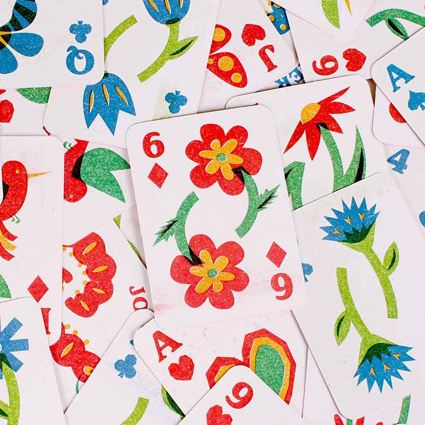 Spread of illustrated playing cards featuring risograph flowers